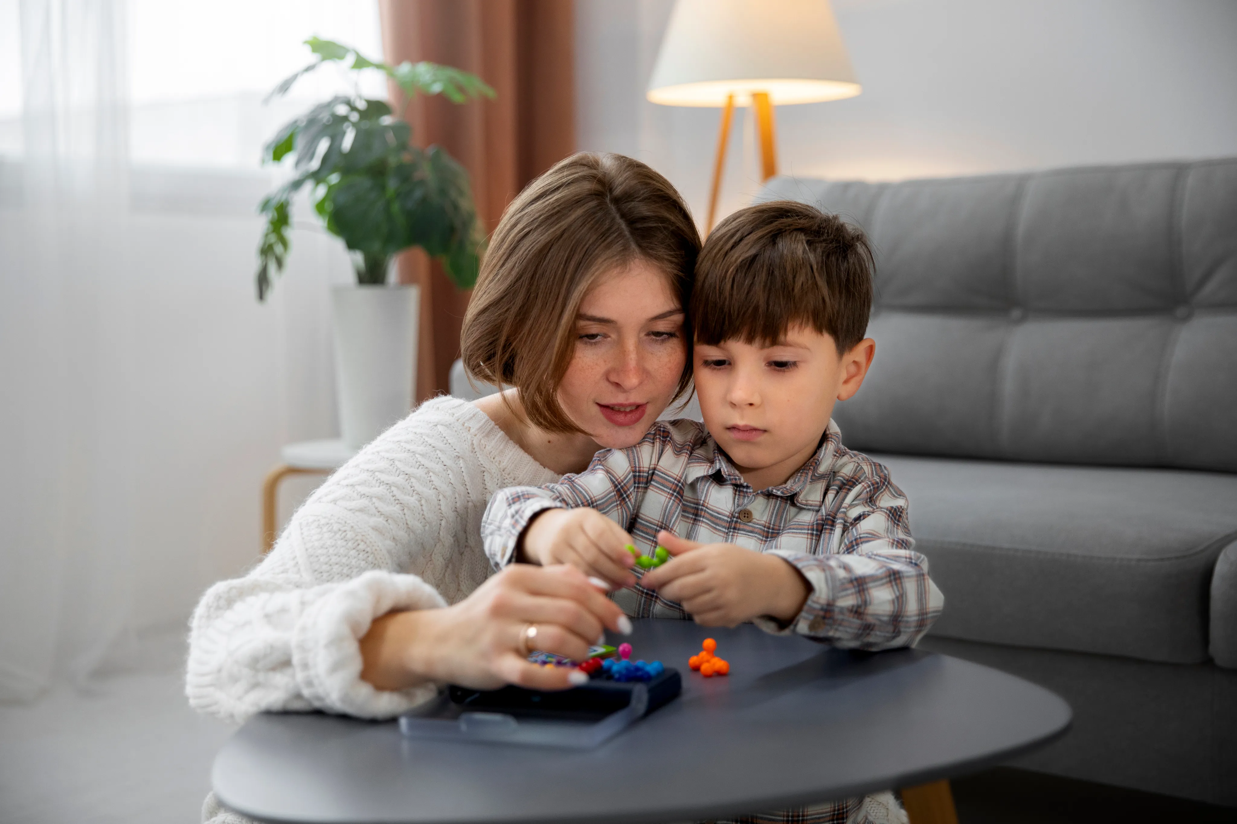 A parent and child playing on a couch with colorful toys at home