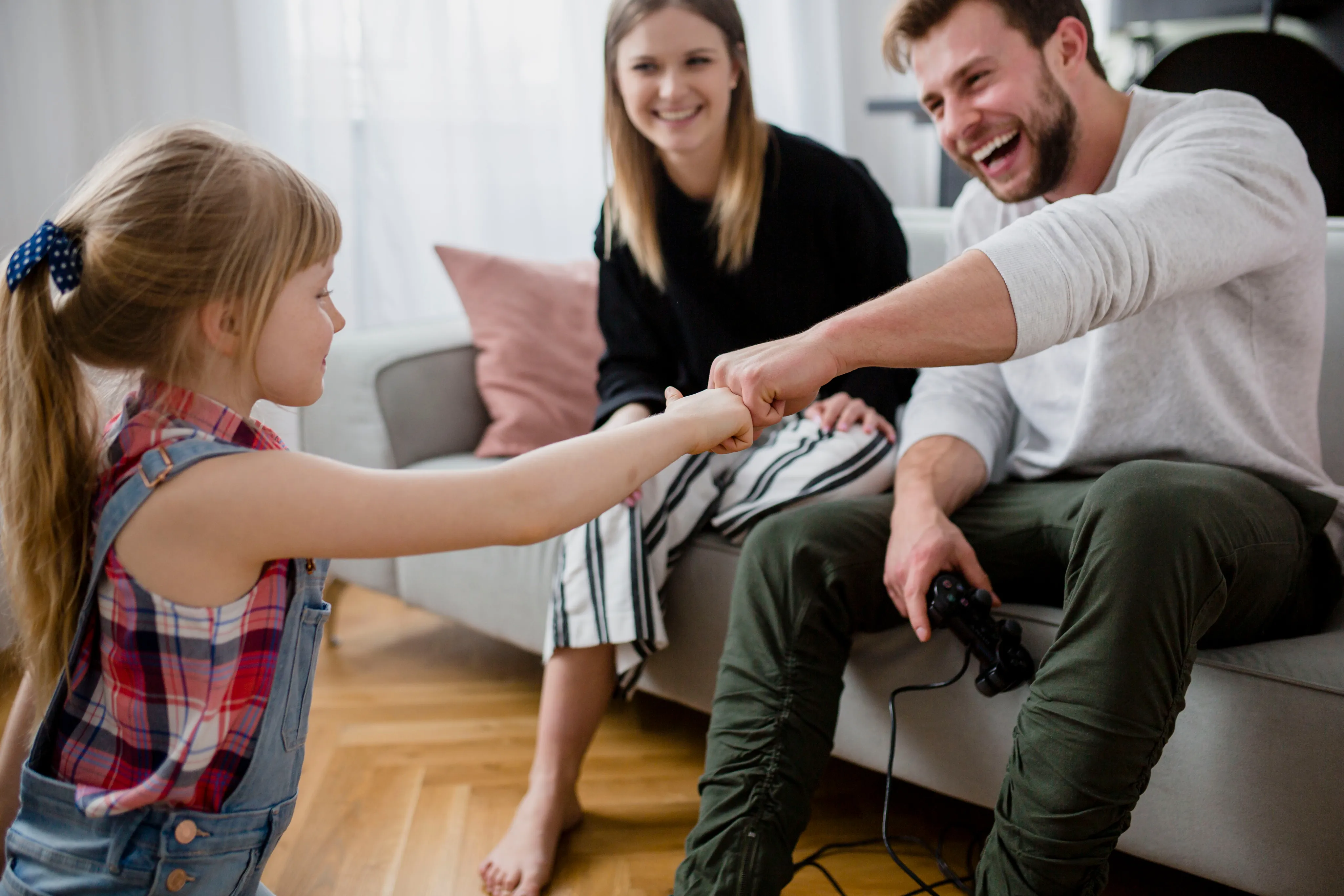 A parent and child playing together in a sunlit playroom